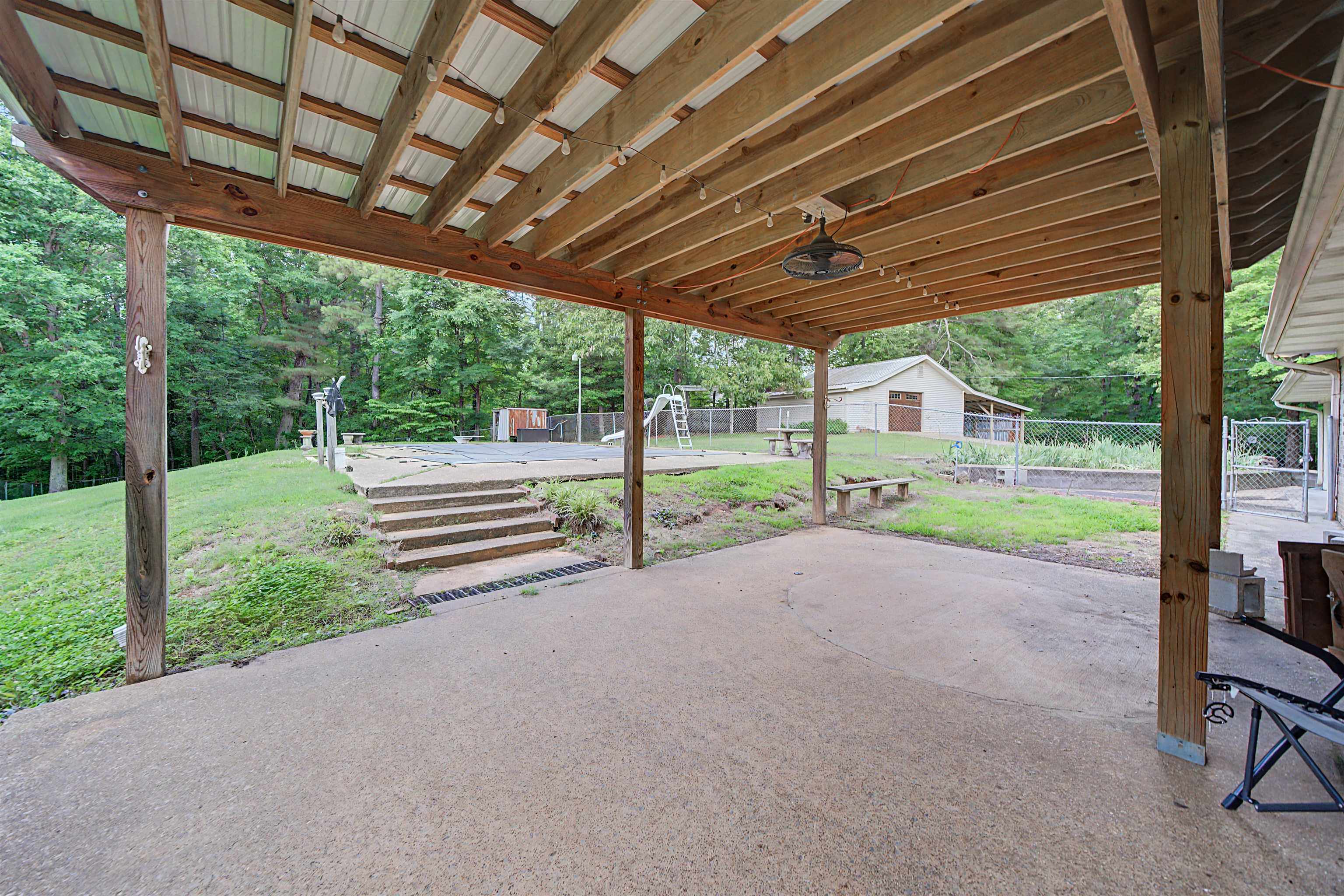 436 Skyline Road Selmer, TN 38375 - Photo 12 of 40 Expansive covered patio featuring a concrete surface, exposed wood beam ceiling, and a metal roof