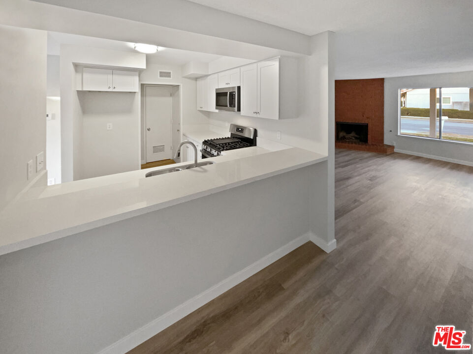 443 Pepper Tree Drive Brea, CA 92821 - Photo 16 of 26 a living room with stainless steel appliances kitchen island a large counter top and a wooden floor