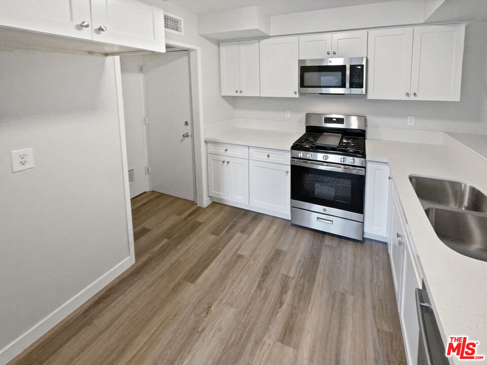 443 Pepper Tree Drive Brea, CA 92821 - Photo 20 of 26 a kitchen with stainless steel appliances a white stove top oven and wooden floors