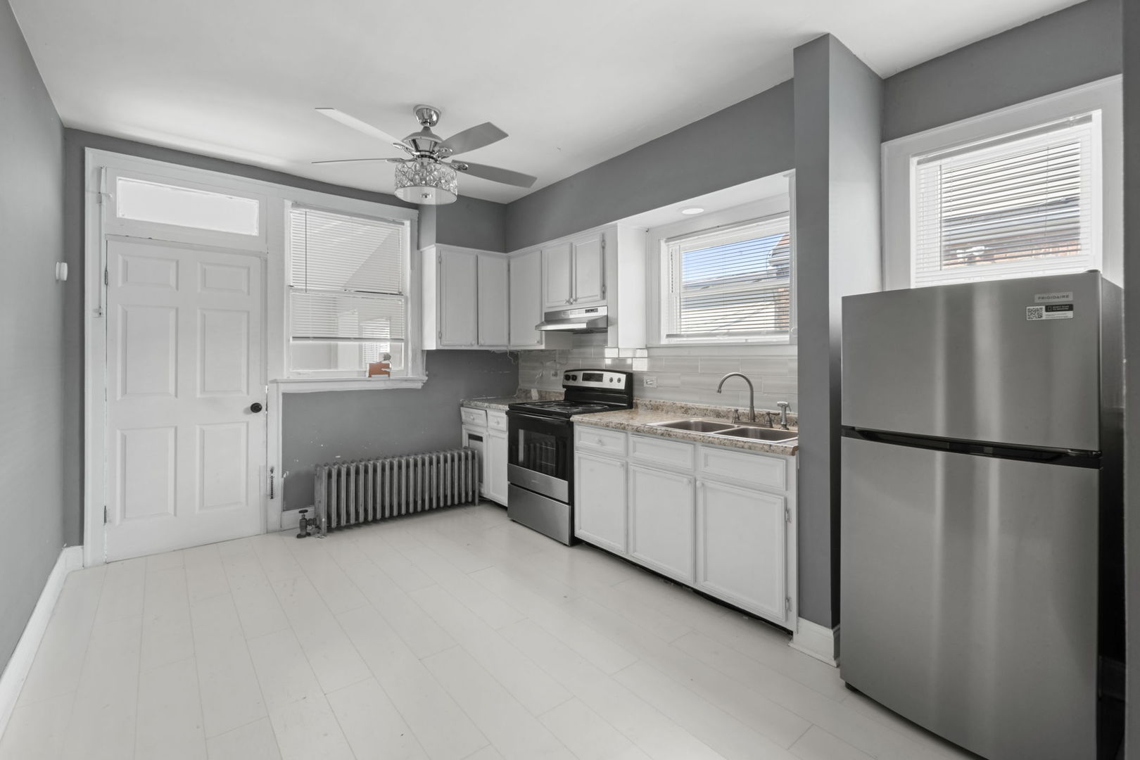429 East 89th Street Chicago, IL 60619 - Photo 8 of 15 a kitchen with a refrigerator a sink and cabinets