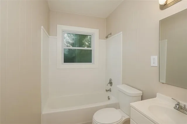 a white toilet sitting next to a bath tub