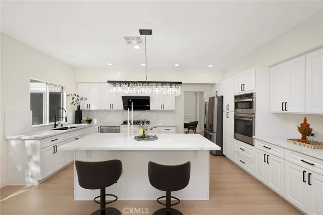 a kitchen with a dining table chairs and refrigerator