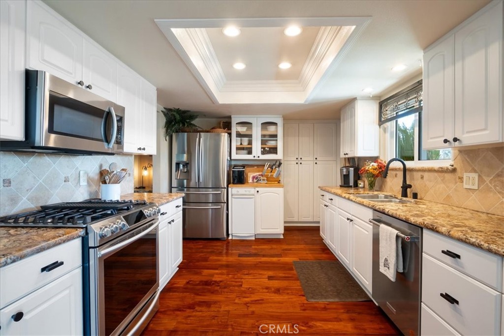 1321 June Street Fallbrook, CA 92028 - Photo 12 of 44 a kitchen with stainless steel appliances granite countertop a stove top oven a sink dishwasher a refrigerator and cabinets with wooden floor