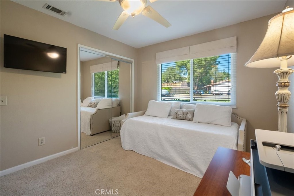 1321 June Street Fallbrook, CA 92028 - Photo 26 of 44 a bedroom with a bed a flat screen tv and a chandelier