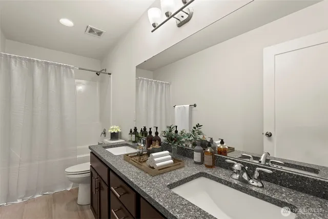 a bathroom with double sink and a mirror