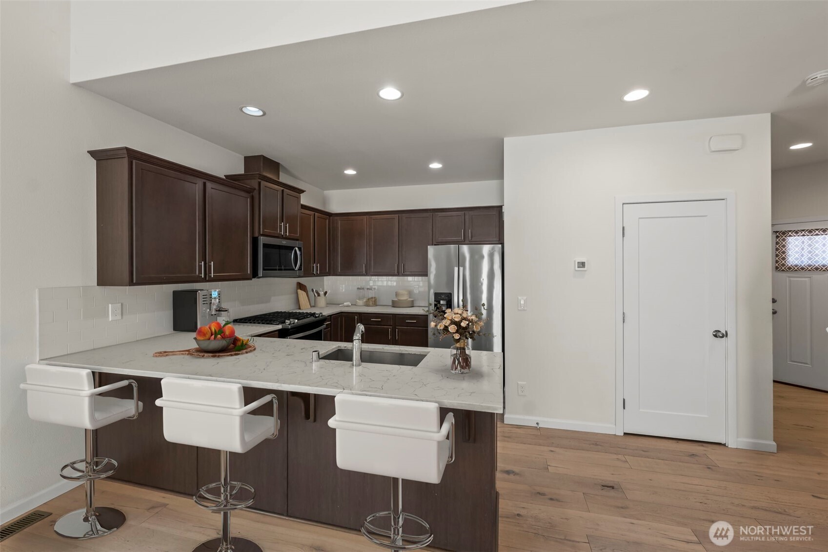 920 East Old Ranch Road, Unit E1 Allyn, WA 98524 - Photo 5 of 20 a kitchen with stainless steel appliances kitchen island granite countertop a refrigerator and a stove top oven