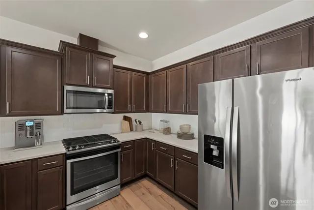 a kitchen with stainless steel appliances and refrigerator
