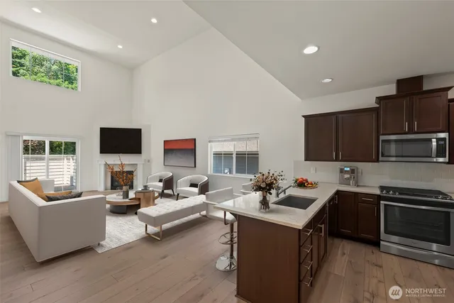 a living room with stainless steel appliances kitchen island granite countertop a sink and a couch