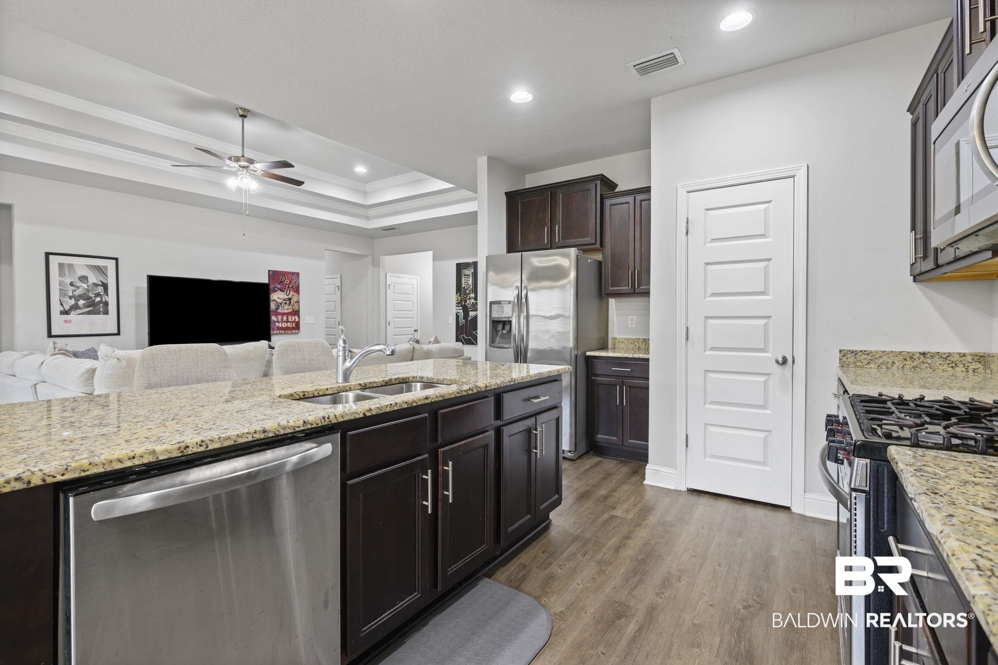 12693 Waxwing Avenue Daphne, AL 36527 - Photo 43 of 43 Kitchen with stainless steel appliances, a ceiling fan, open floor plan, dark wood-type flooring, and light stone counters