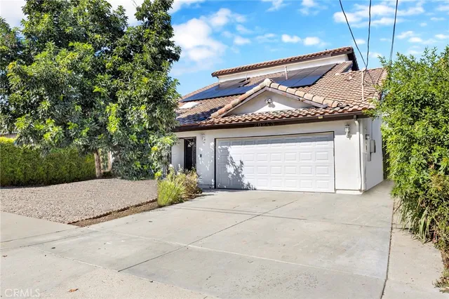 a front view of a house with a garden and garage