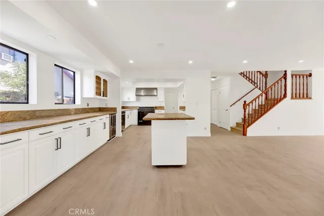 a large white kitchen with lots of counter space and windows