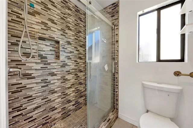 a bathroom with a toilet and a shower