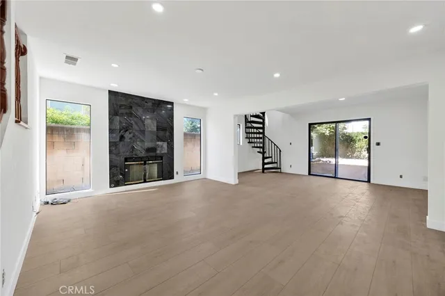 a view of an empty room with a window and a kitchen