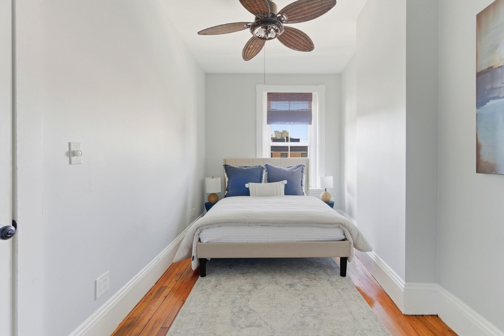 592 Columbus Avenue, Unit PH1 Boston, MA 02118 - Photo 5 of 9 a bedroom with a bed and a chandelier