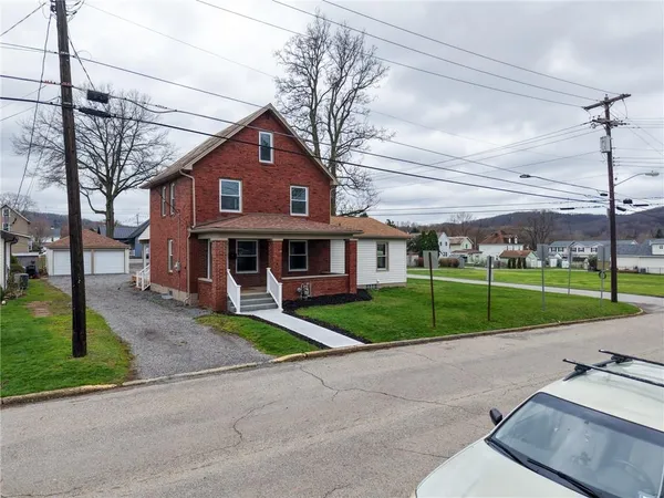 a view of a big house with a big yard and large trees
