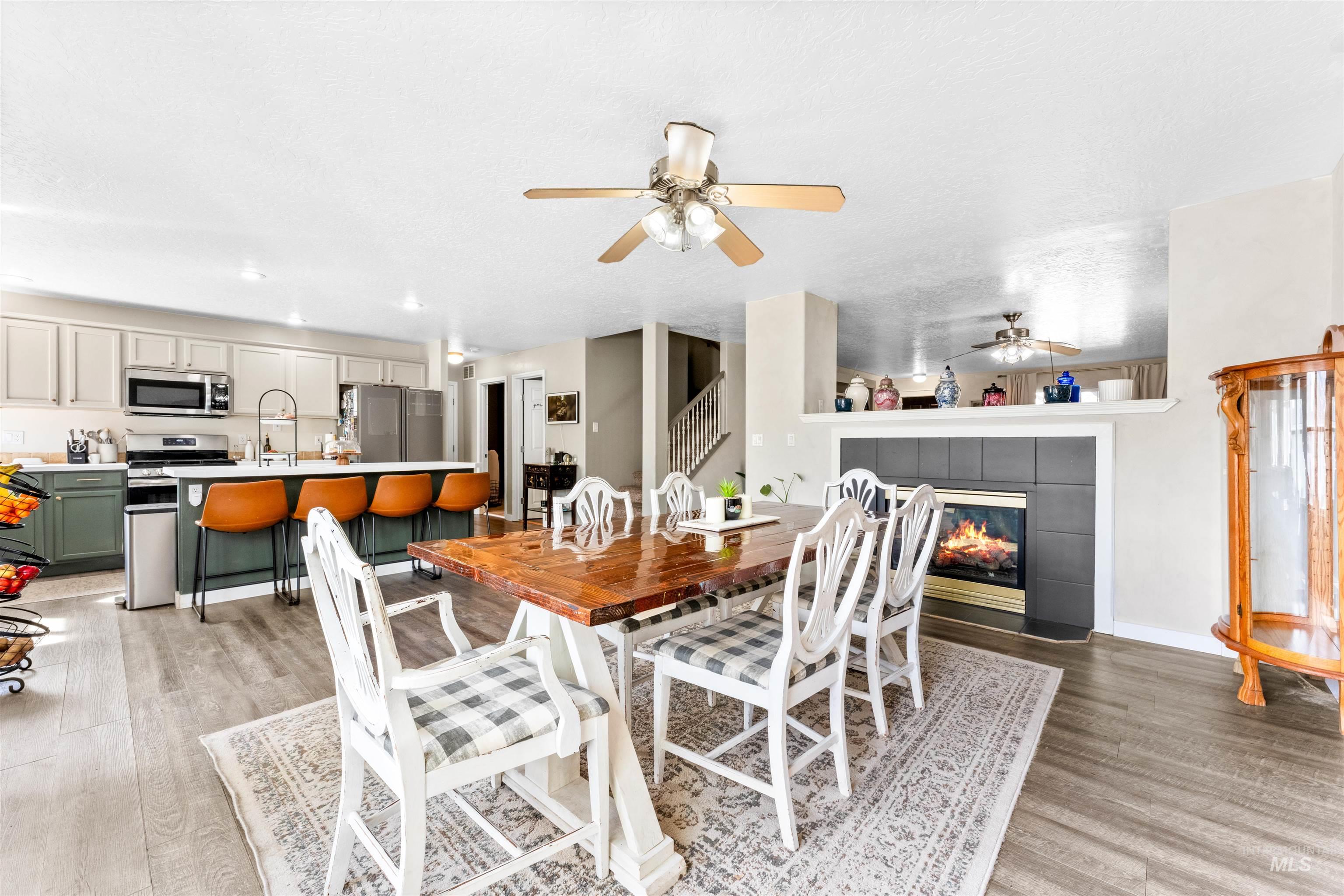 5021 Lathrop Place Caldwell, ID 83607 - Photo 12 of 43 Dining space featuring light wood-style floors, a tile fireplace, a ceiling fan, and recessed lighting