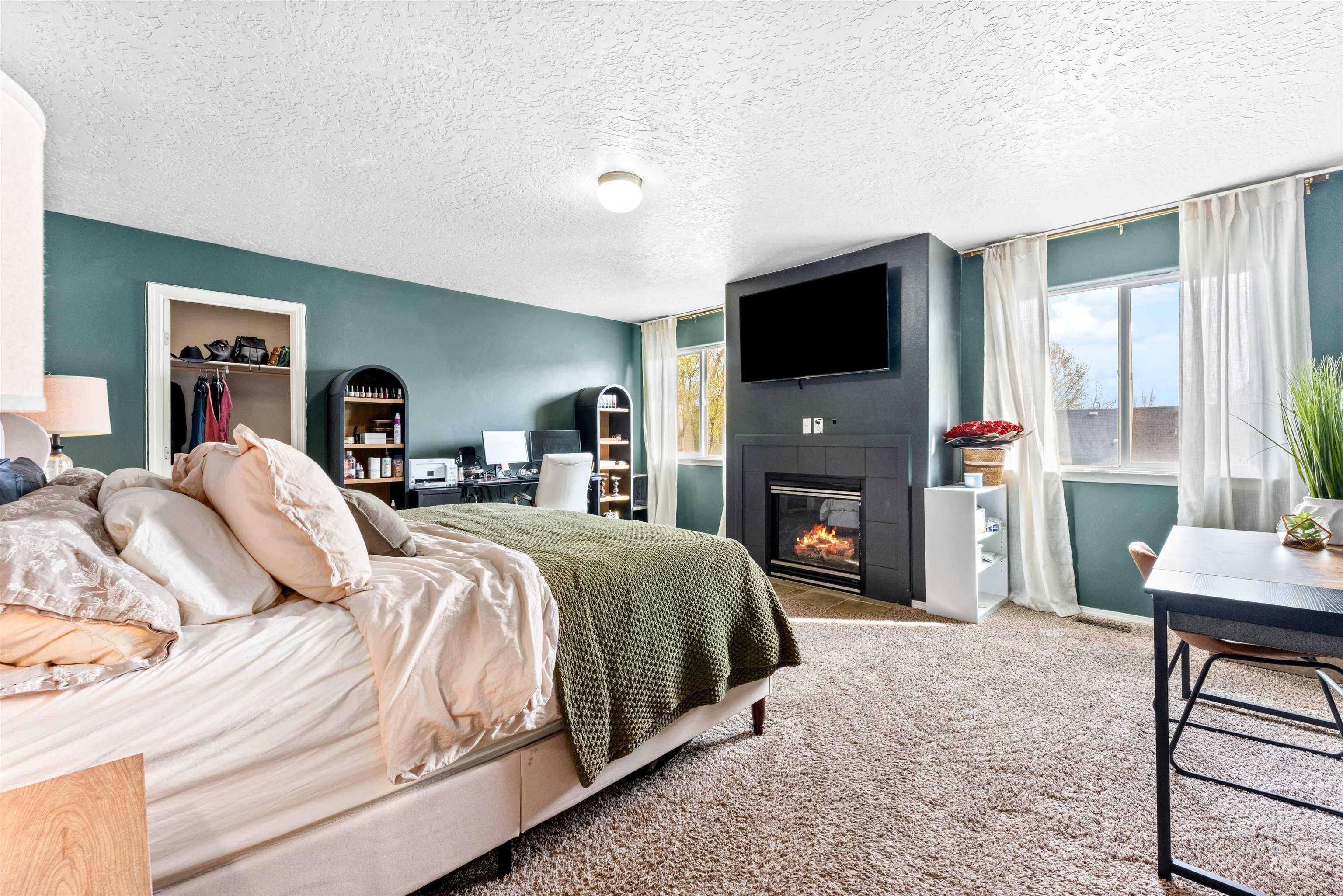 5021 Lathrop Place Caldwell, ID 83607 - Photo 21 of 43 Bedroom featuring a fireplace, carpet flooring, a textured ceiling, and a spacious closet