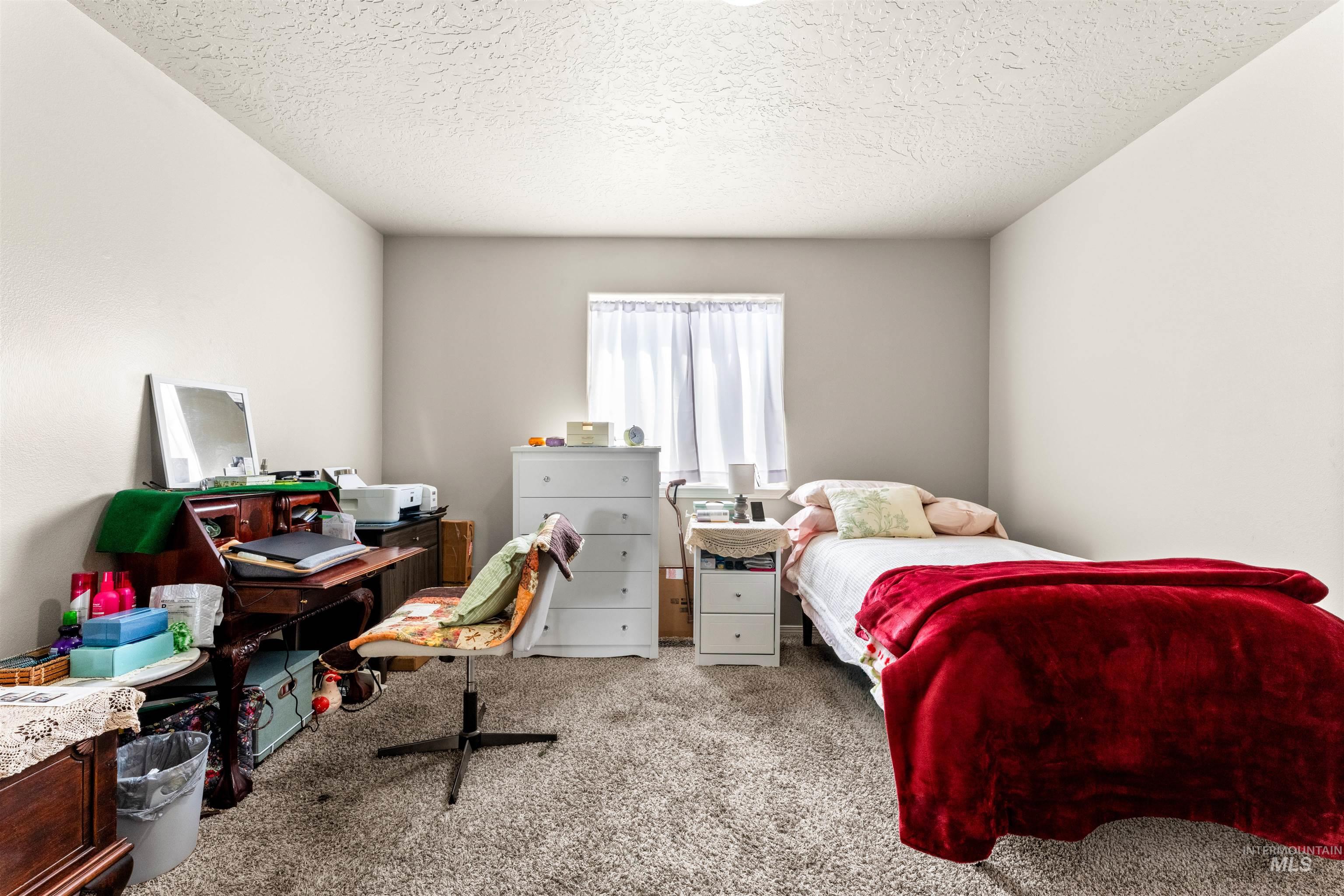 5021 Lathrop Place Caldwell, ID 83607 - Photo 27 of 43 Bedroom featuring carpet floors and a textured ceiling
