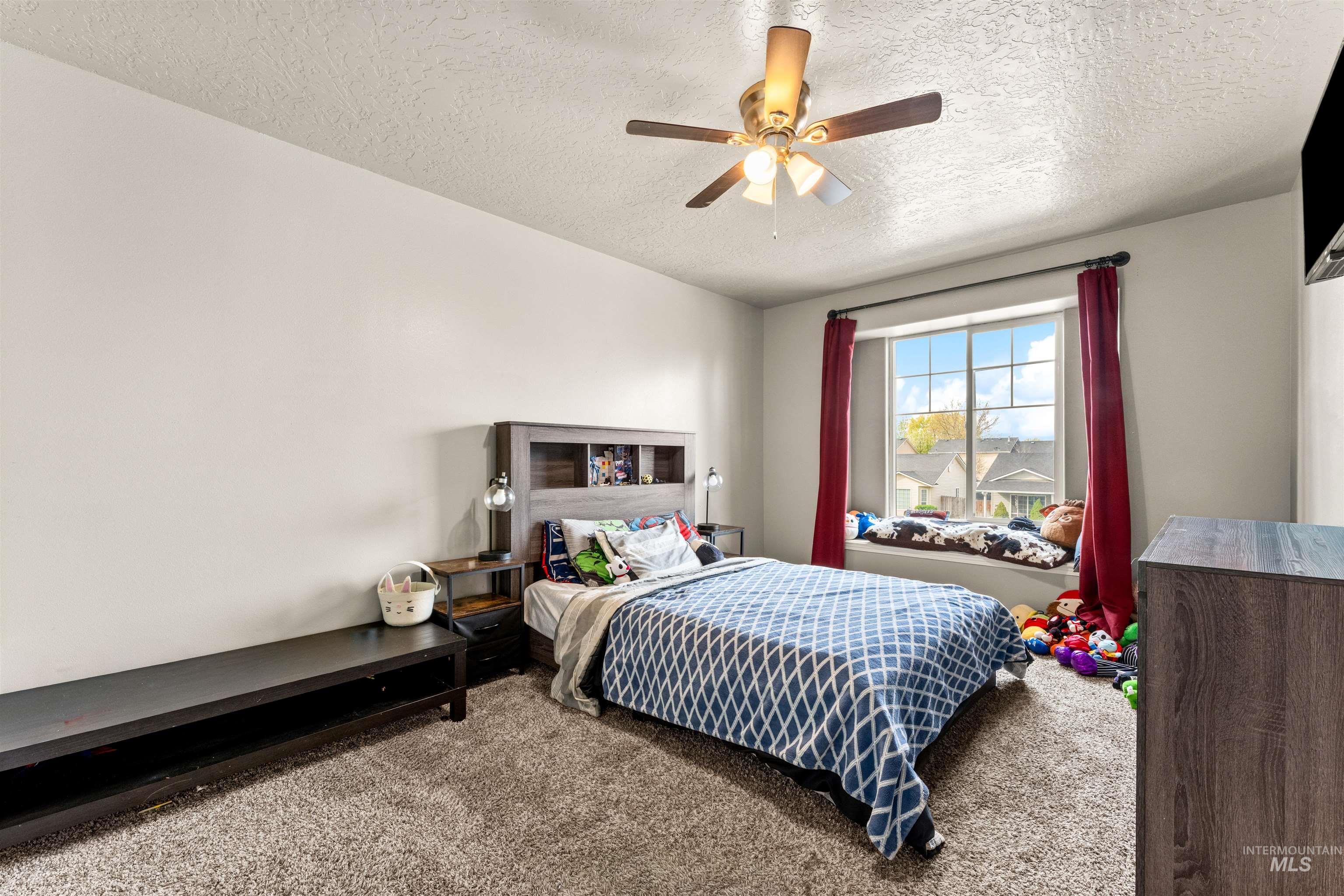 5021 Lathrop Place Caldwell, ID 83607 - Photo 29 of 43 Carpeted bedroom with a ceiling fan and a textured ceiling