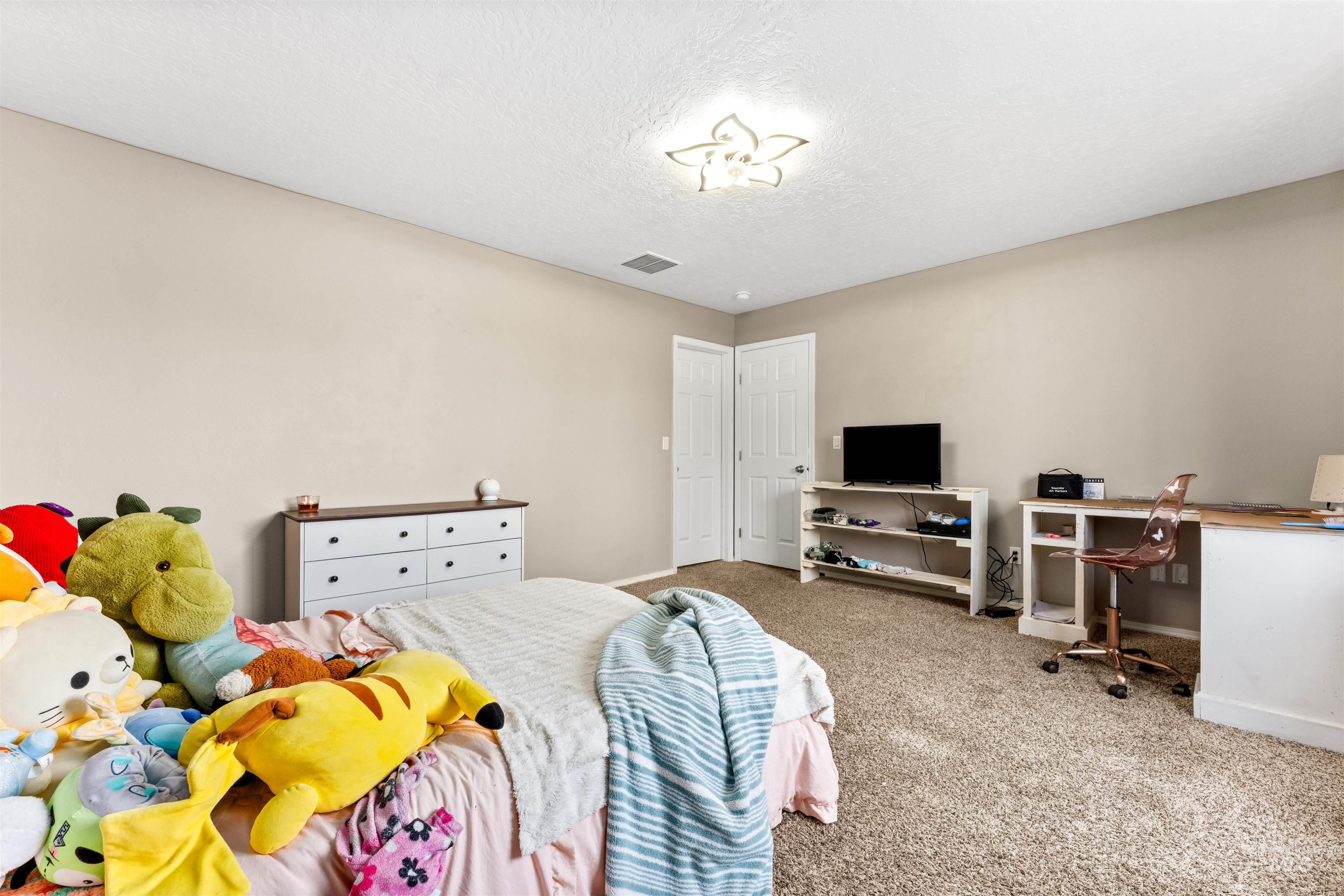 5021 Lathrop Place Caldwell, ID 83607 - Photo 36 of 43 Bedroom with carpet, a textured ceiling, and a desk