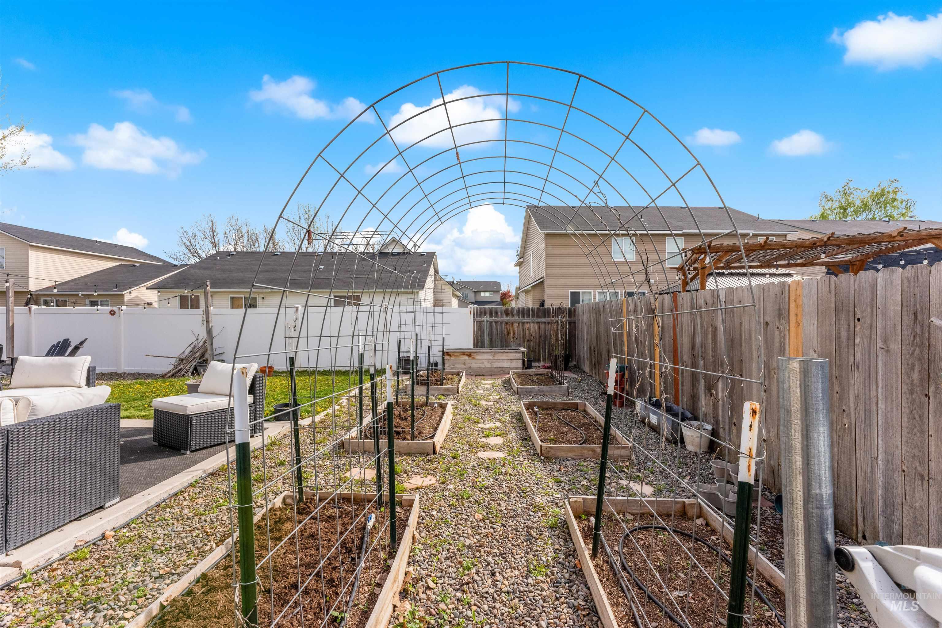 5021 Lathrop Place Caldwell, ID 83607 - Photo 41 of 43 Fenced backyard with a patio area, a residential view, and a garden