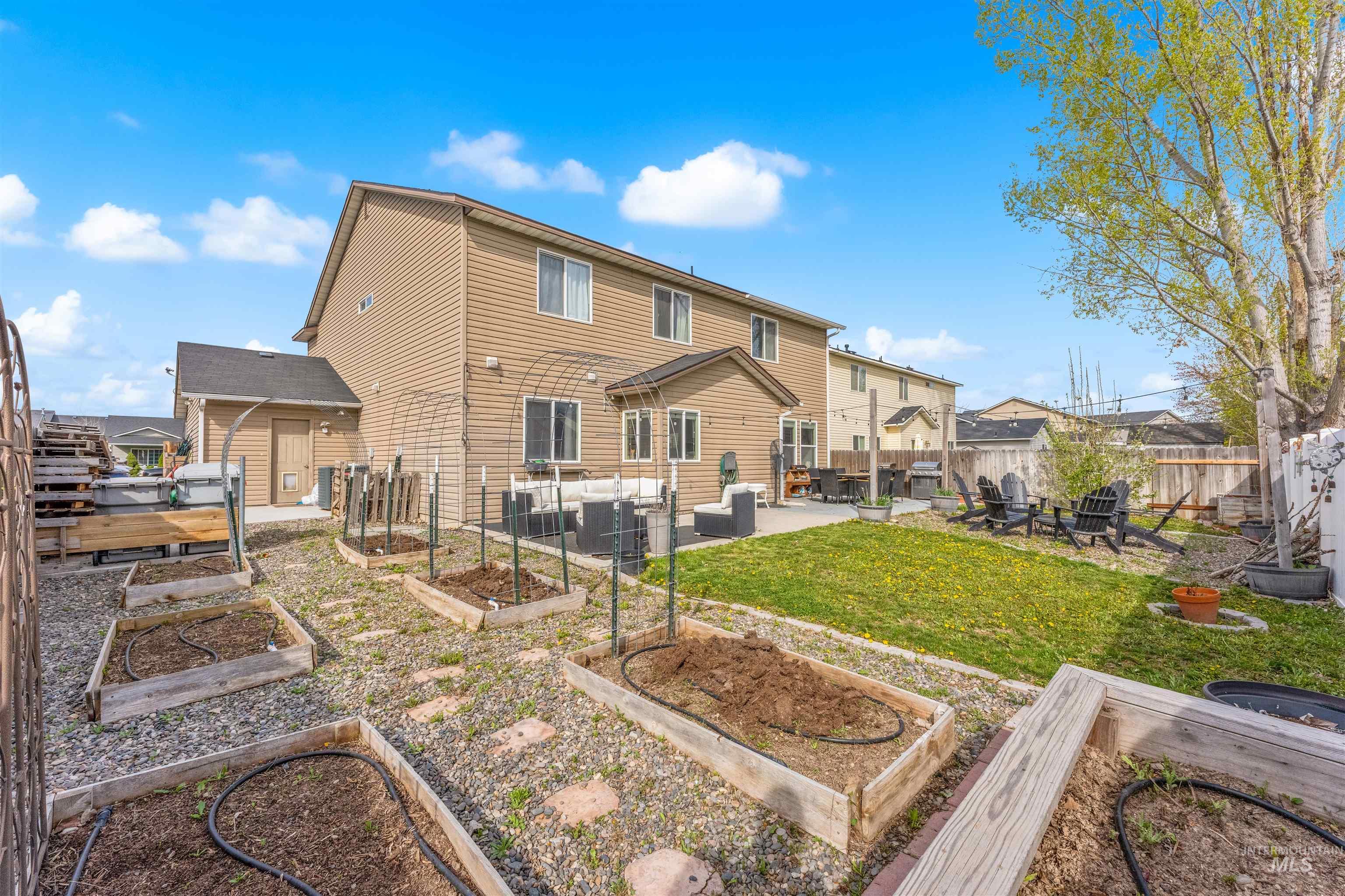 5021 Lathrop Place Caldwell, ID 83607 - Photo 42 of 43 Rear view of property with a patio, a fenced backyard, a garden, and a residential view