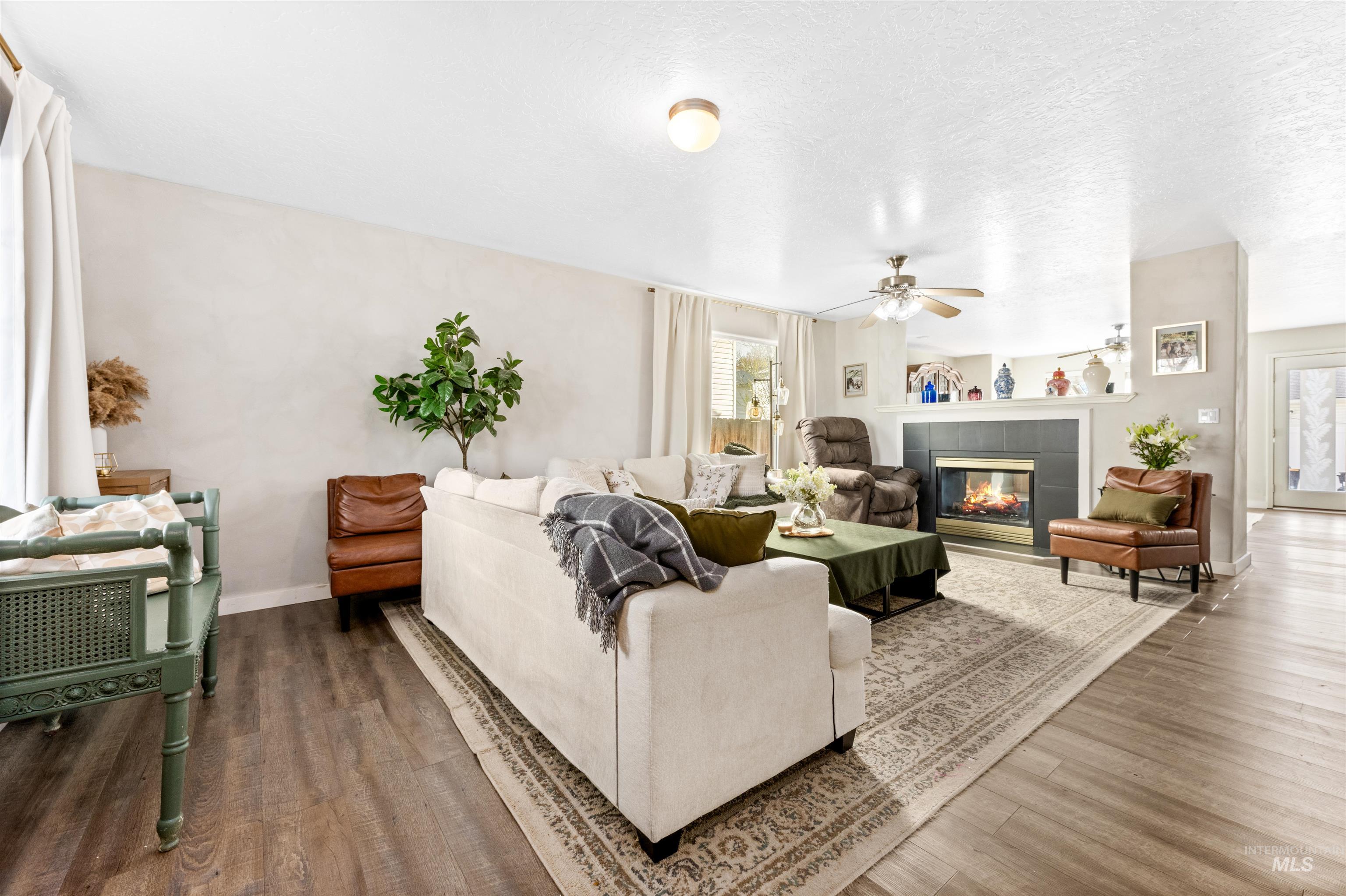 5021 Lathrop Place Caldwell, ID 83607 - Photo 5 of 43 Living area featuring a tile fireplace, wood finished floors, and a textured ceiling
