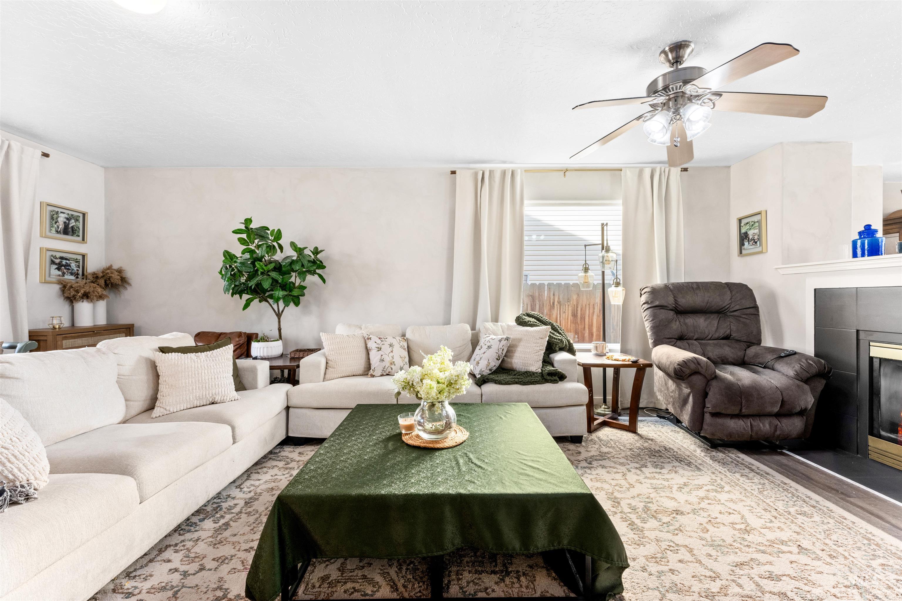 5021 Lathrop Place Caldwell, ID 83607 - Photo 8 of 43 Living area with a tiled fireplace, a ceiling fan, and wood finished floors