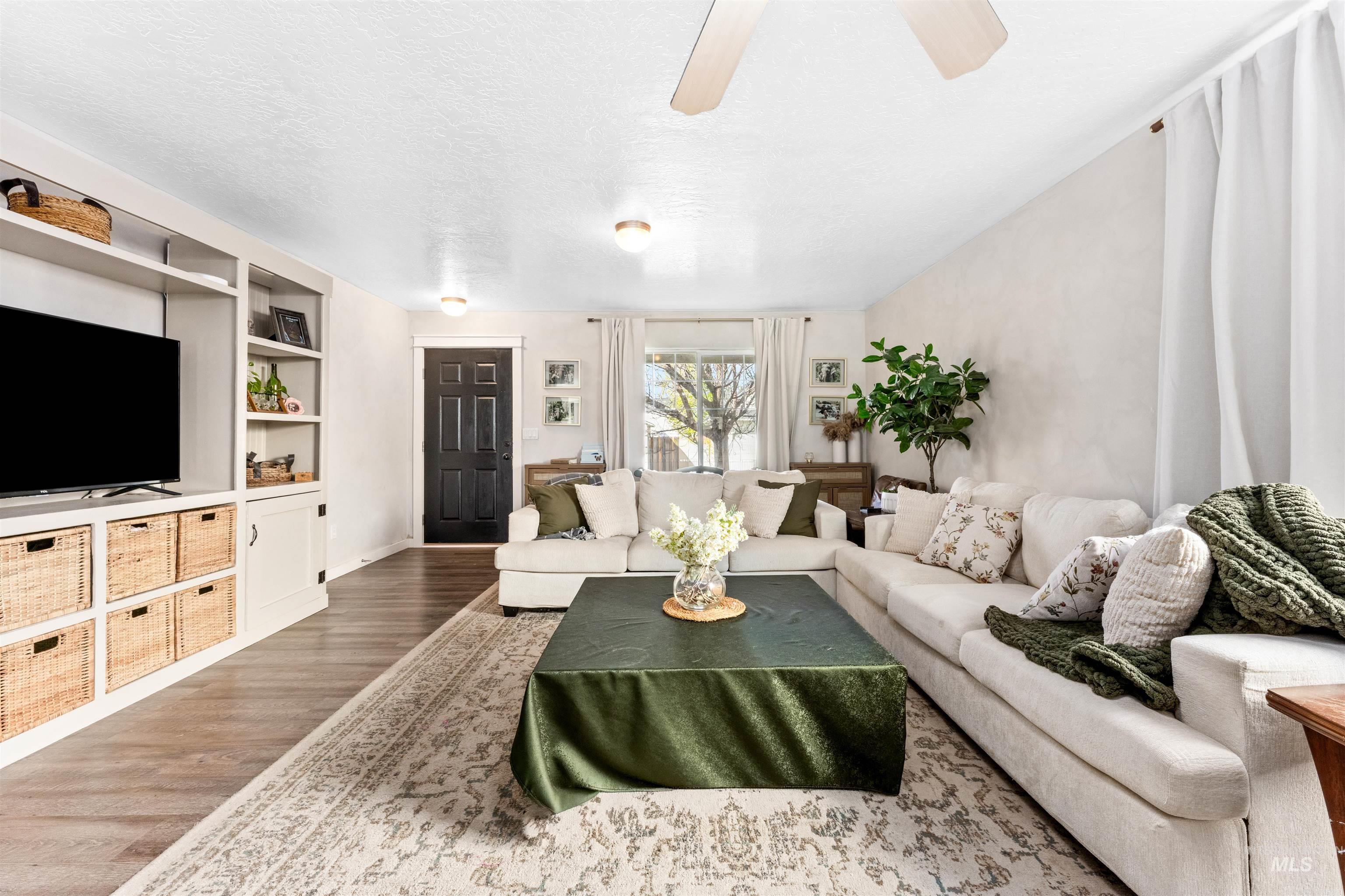 5021 Lathrop Place Caldwell, ID 83607 - Photo 9 of 43 Living room featuring wood finished floors, a textured ceiling, ceiling fan, and built in shelves