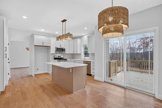 a kitchen with granite countertop a sink cabinets and wooden floor