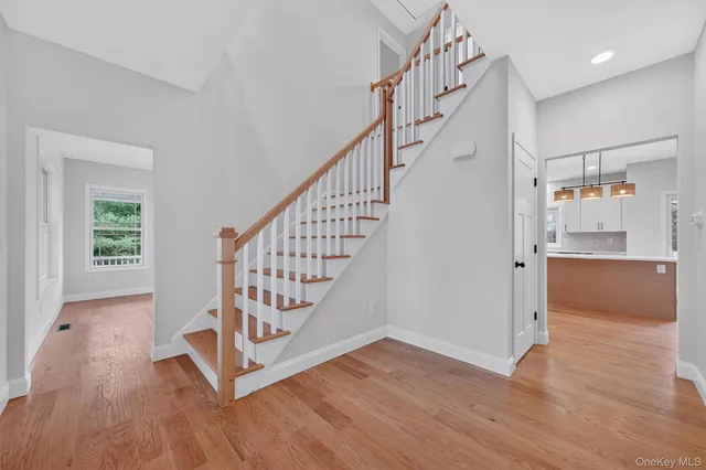 a view of empty room with wooden floor and window