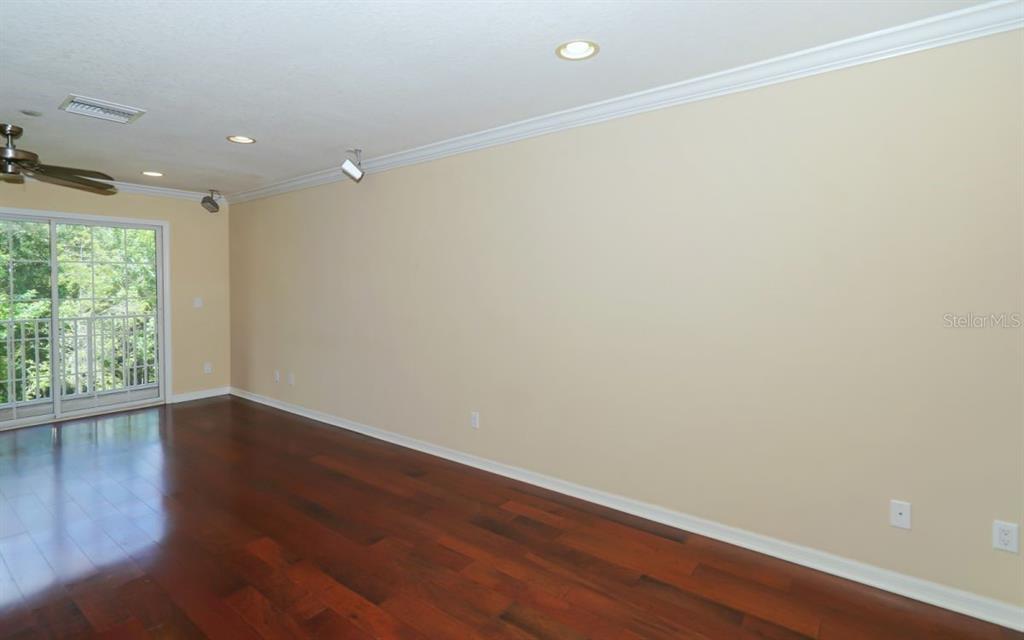 7339 Black Walnut Way Lakewood Ranch, FL 34202 - Photo 4 of 27 a view of an empty room with wooden floor and a window