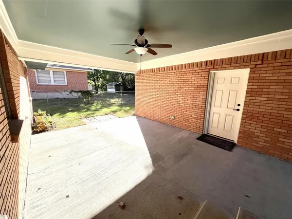 a view of a porch with a floor to ceiling window and a ceiling fan