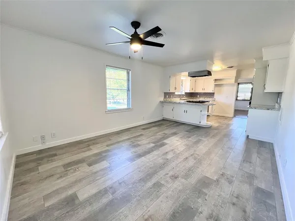 a large white kitchen with a dishwasher a stove and a large window