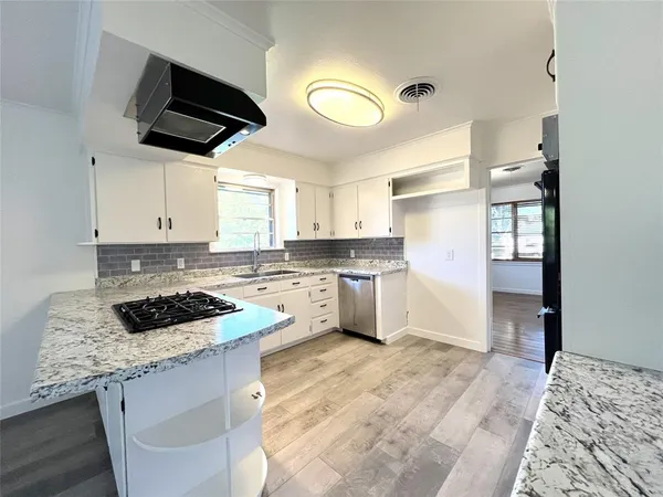 a kitchen with granite countertop a sink cabinets and window