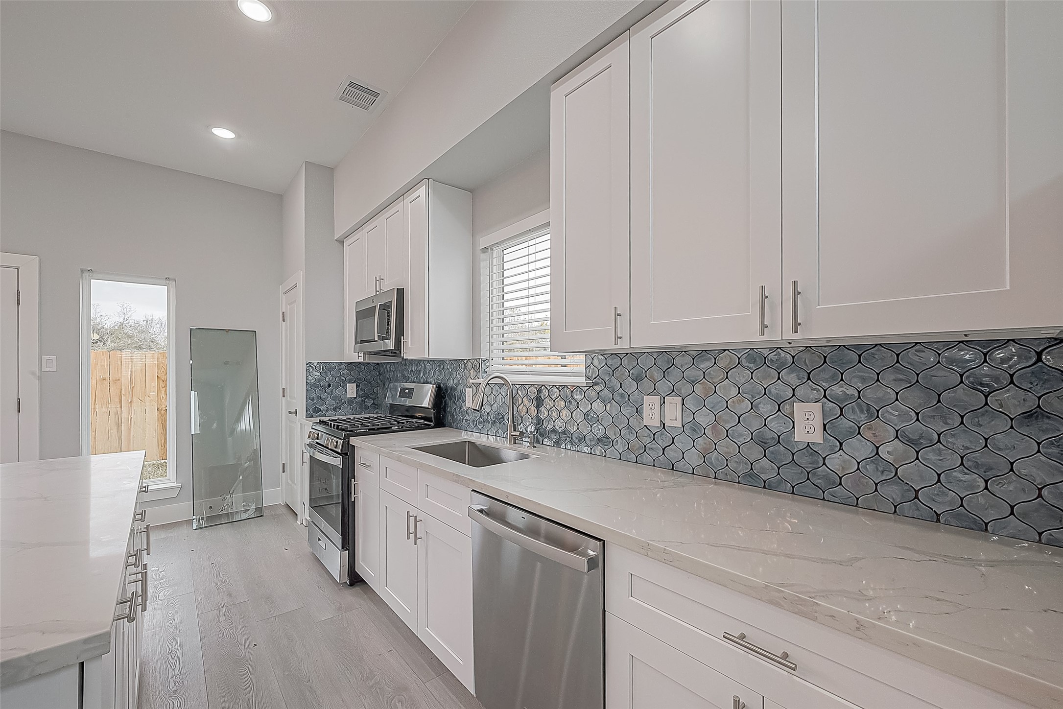9204 Buffum Street Houston, TX 77051 - Photo 3 of 19 a kitchen with a sink stove and cabinets