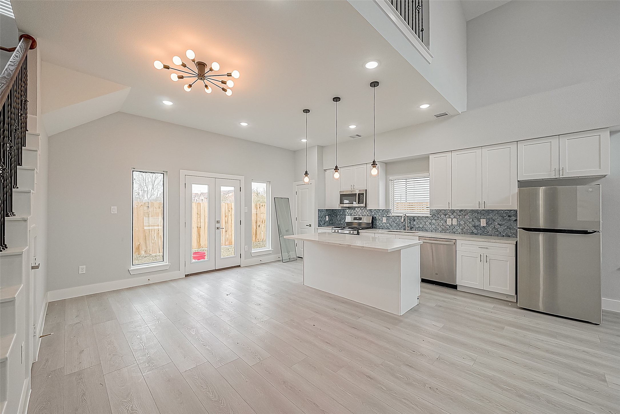 9204 Buffum Street Houston, TX 77051 - Photo 5 of 19 a large white kitchen with a refrigerator a sink dishwasher a stove and white cabinets with wooden floor