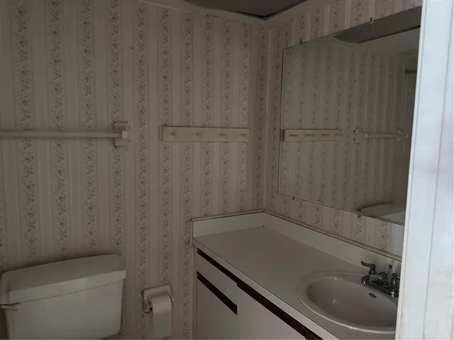 a bathroom with a granite countertop sink toilet and vanity