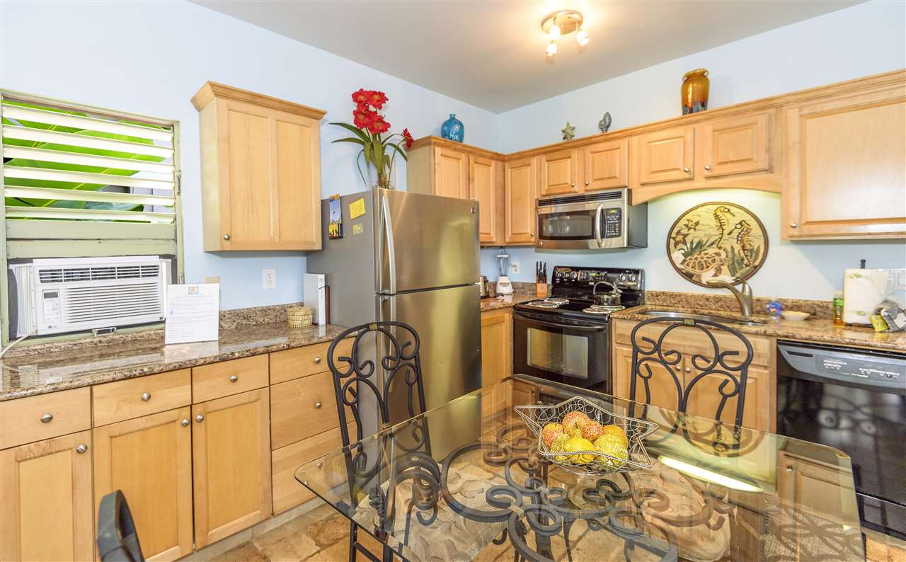 4435 Lower Honoapiilani Road, Unit 115 Lahaina, HI 96761 - Photo 6 of 26 a kitchen with stainless steel appliances granite countertop a stove a sink and a refrigerator