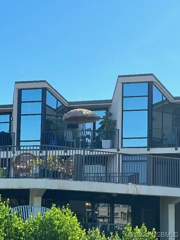 a roof deck with table and chairs and potted plants