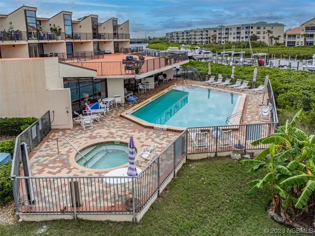 an aerial view of a house with swimming pool and a chairs