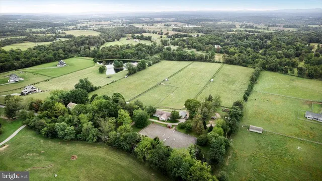 an aerial view of residential houses with outdoor space and trees