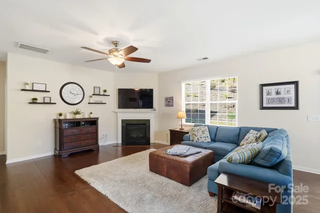 a living room with furniture a fireplace a clock and a window
