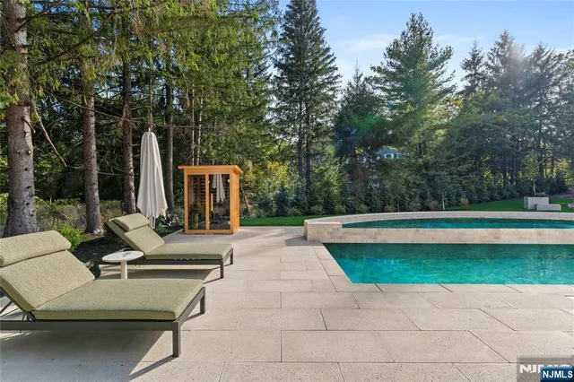 a view of backyard with swimming pool and seating space