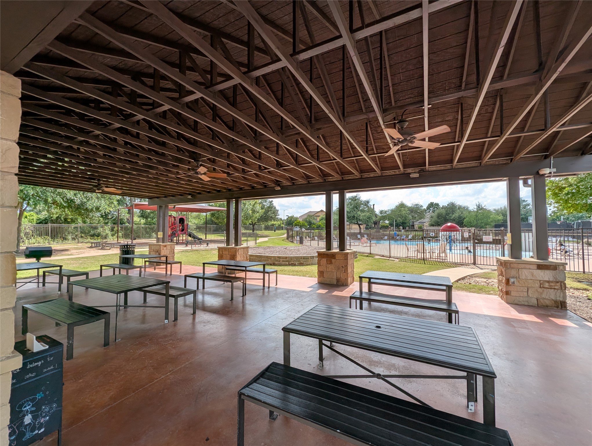 14502 McCoy Loop Austin, TX 78717 - Photo 22 of 26 Expansive covered pavilion featuring a high-pitched wooden beam ceiling, multiple ceiling fans, and an exposed aggregate concrete floor