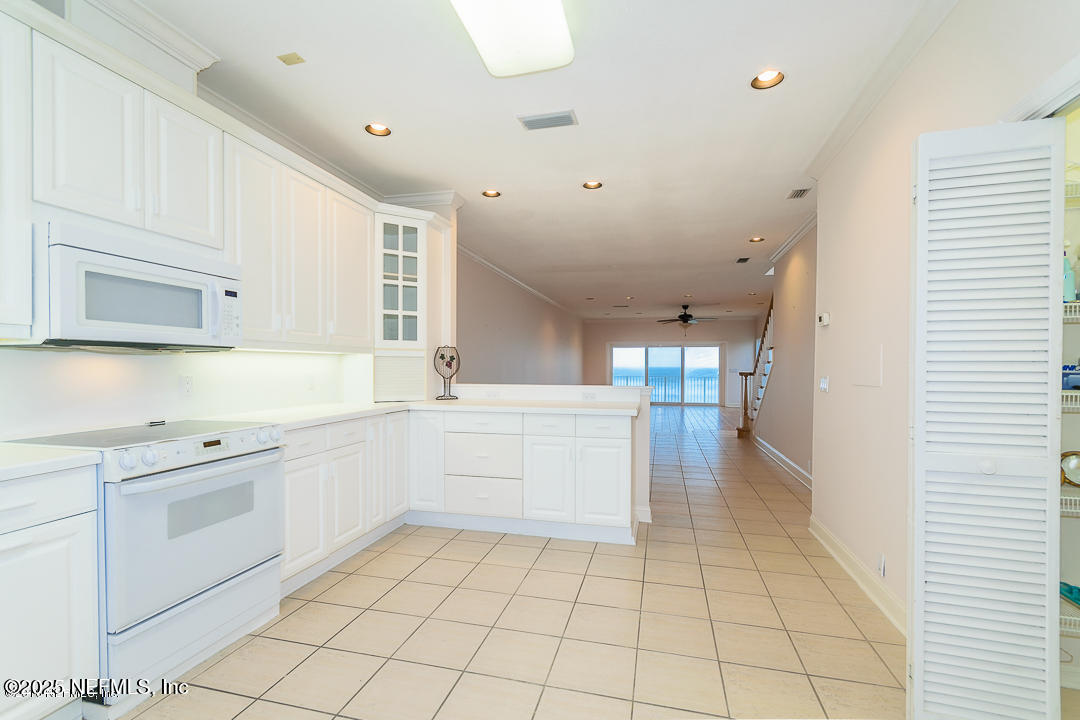 1626 Strand Street Neptune Beach, FL 32266 - Photo 43 of 51 a kitchen with white cabinets appliances and a sink