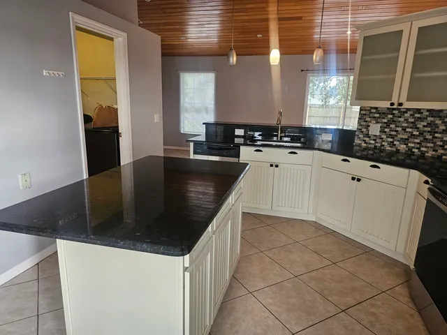 a kitchen with granite countertop a sink and cabinets