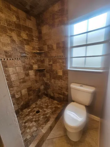 a bathroom with a toilet and a shower