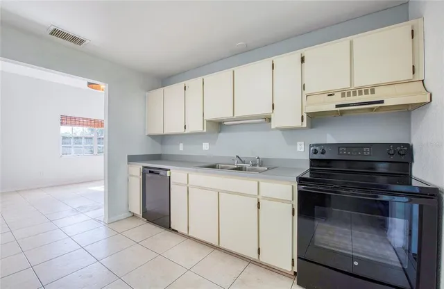 a kitchen with stainless steel appliances granite countertop a stove and a white cabinets