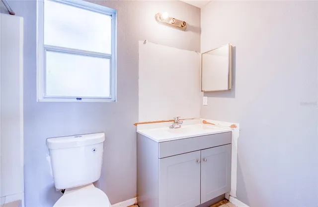 a bathroom with a toilet sink and mirror